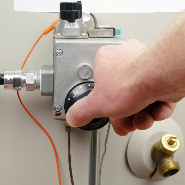 Checking the thermostat on a water heater during a routine water heater repair
